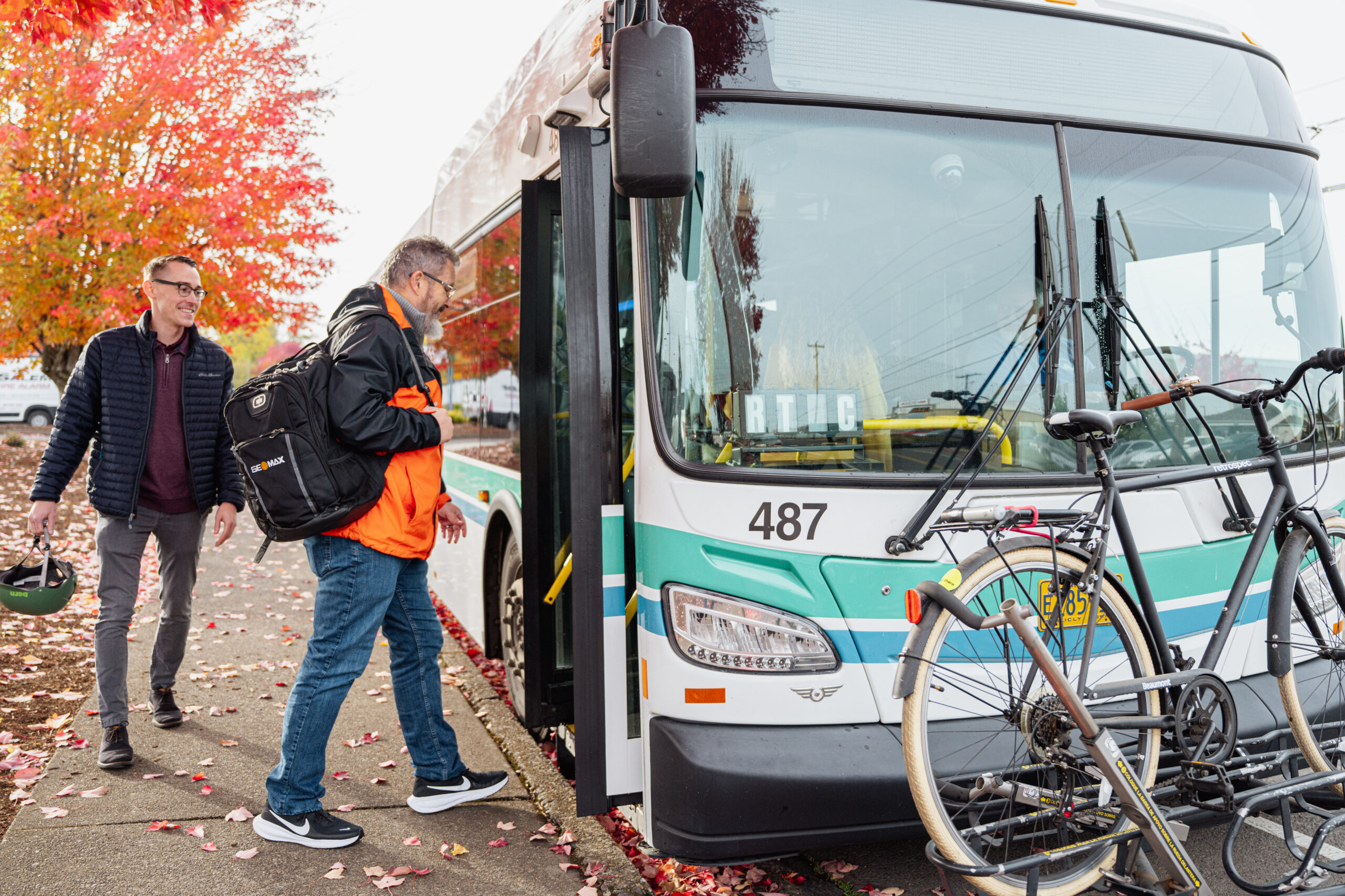 People boarding a bus in the fall.