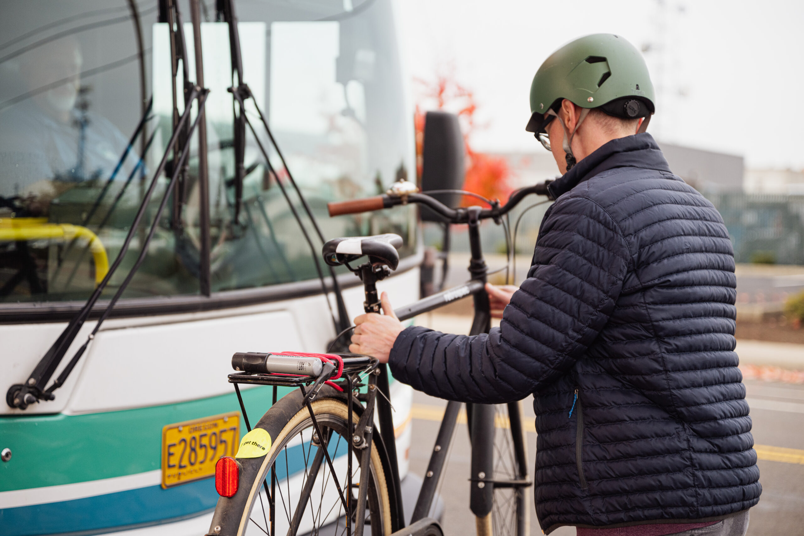 A person mounting a bike to the front of a transit bus.