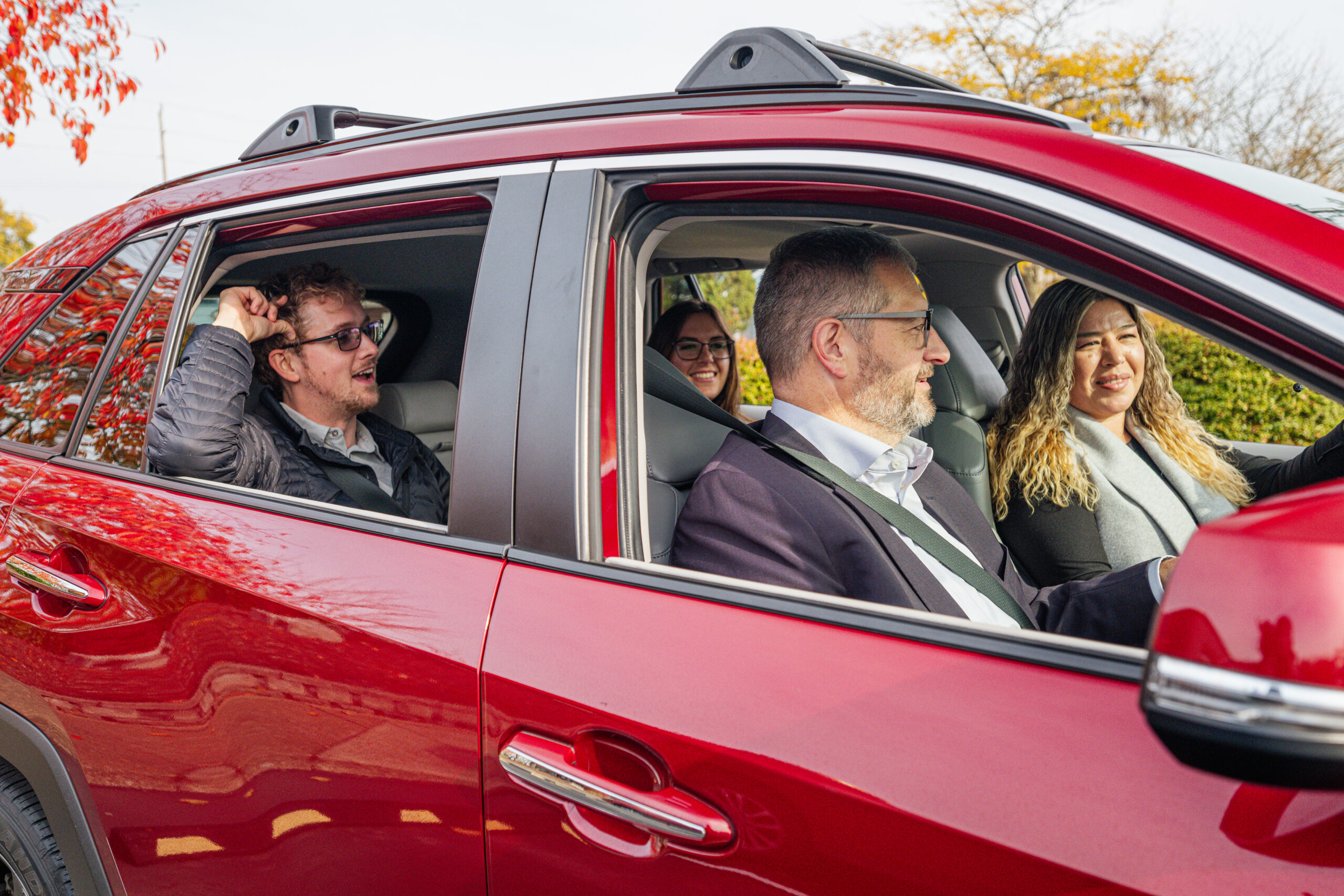 A large car with four people in work attire.