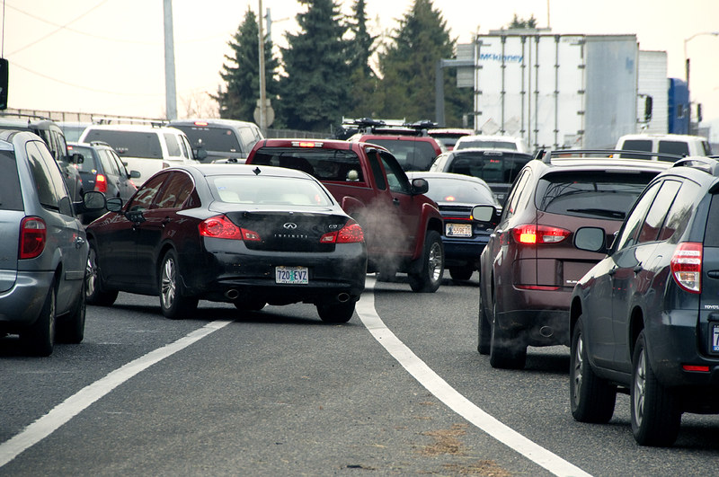 Cars changing lanes on a packed highway.